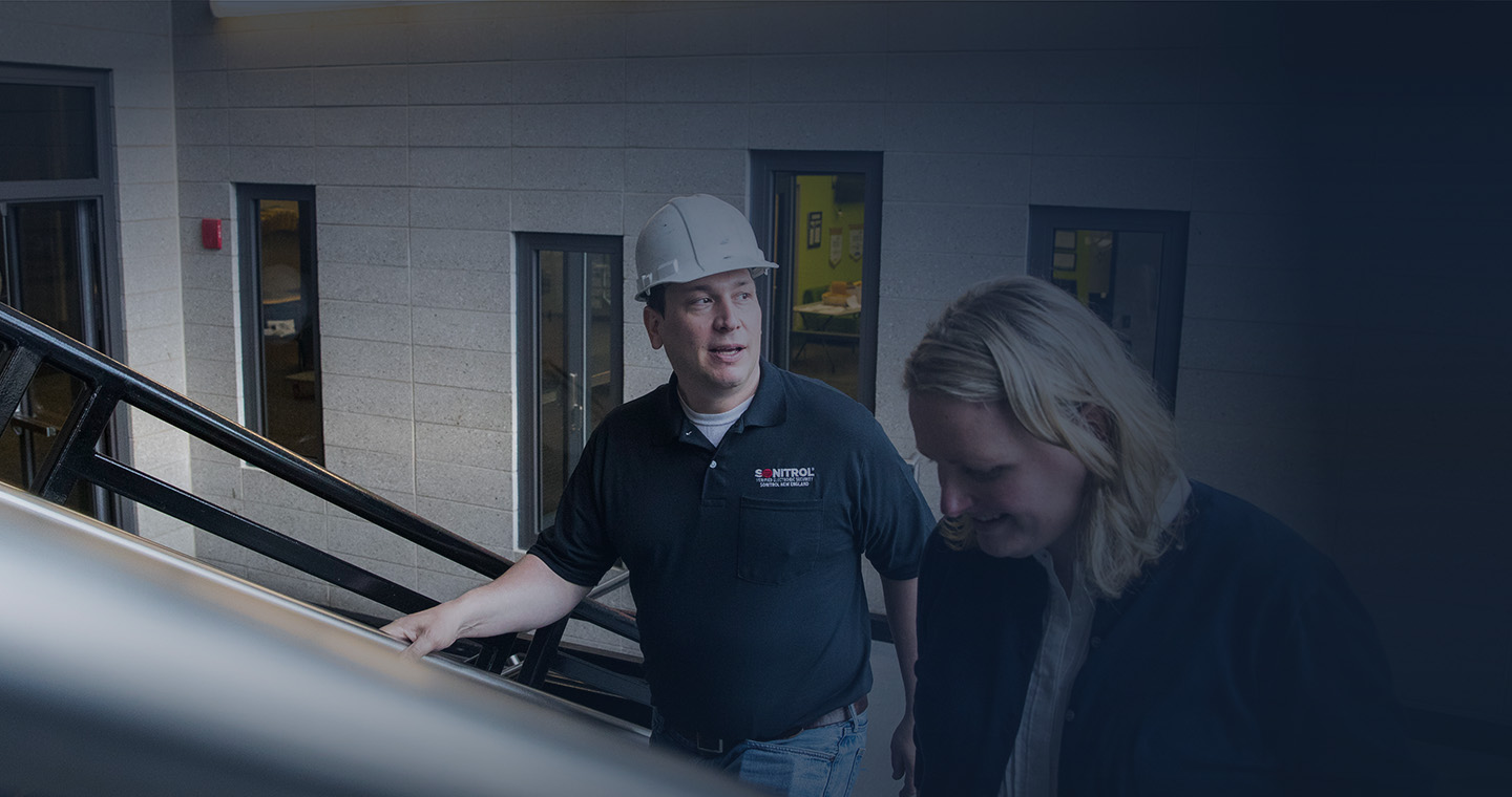 Sonitrol employee conversing with office worker.