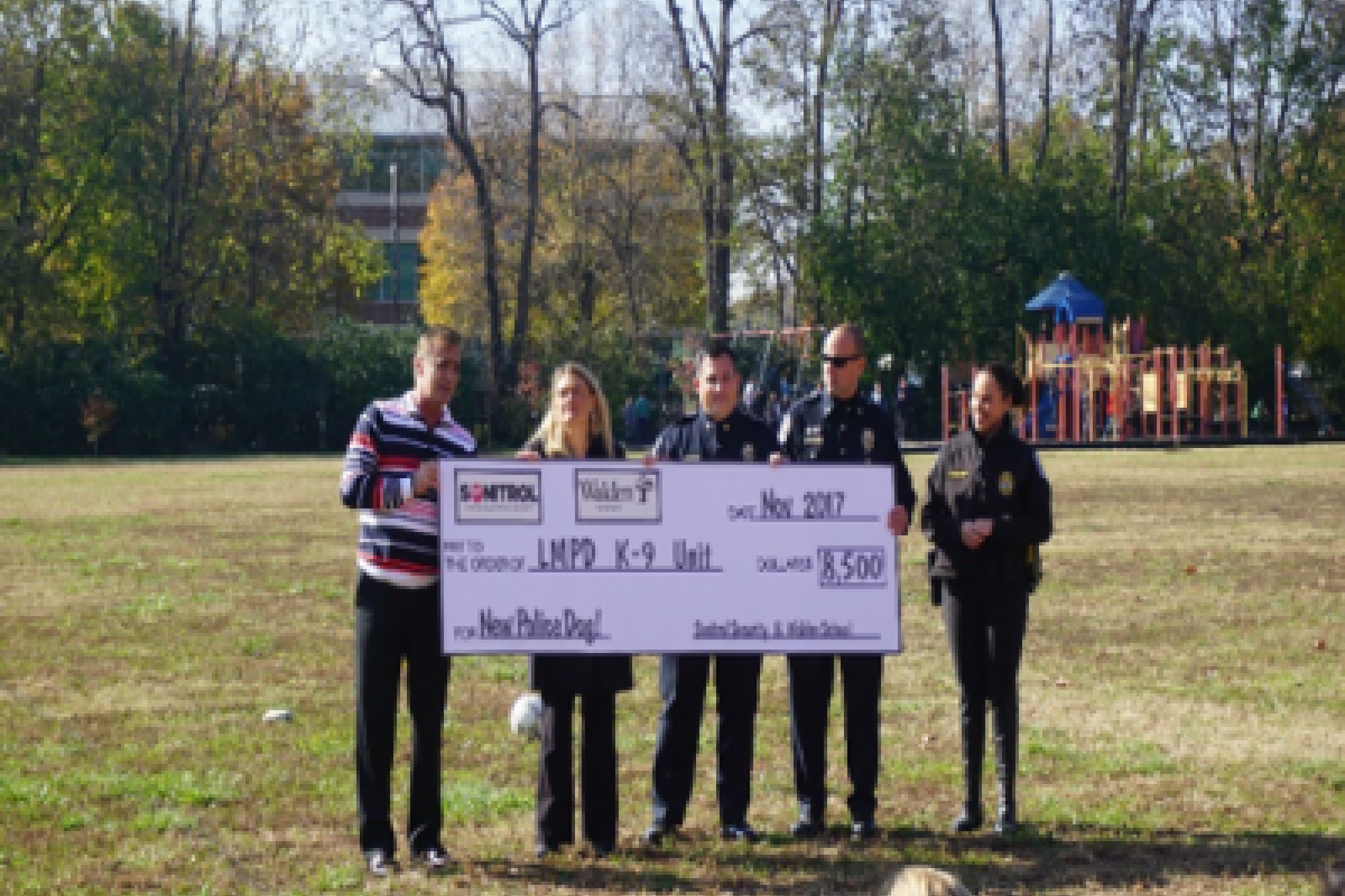 LMPD officers hold large check for Sonitrol K9 donation