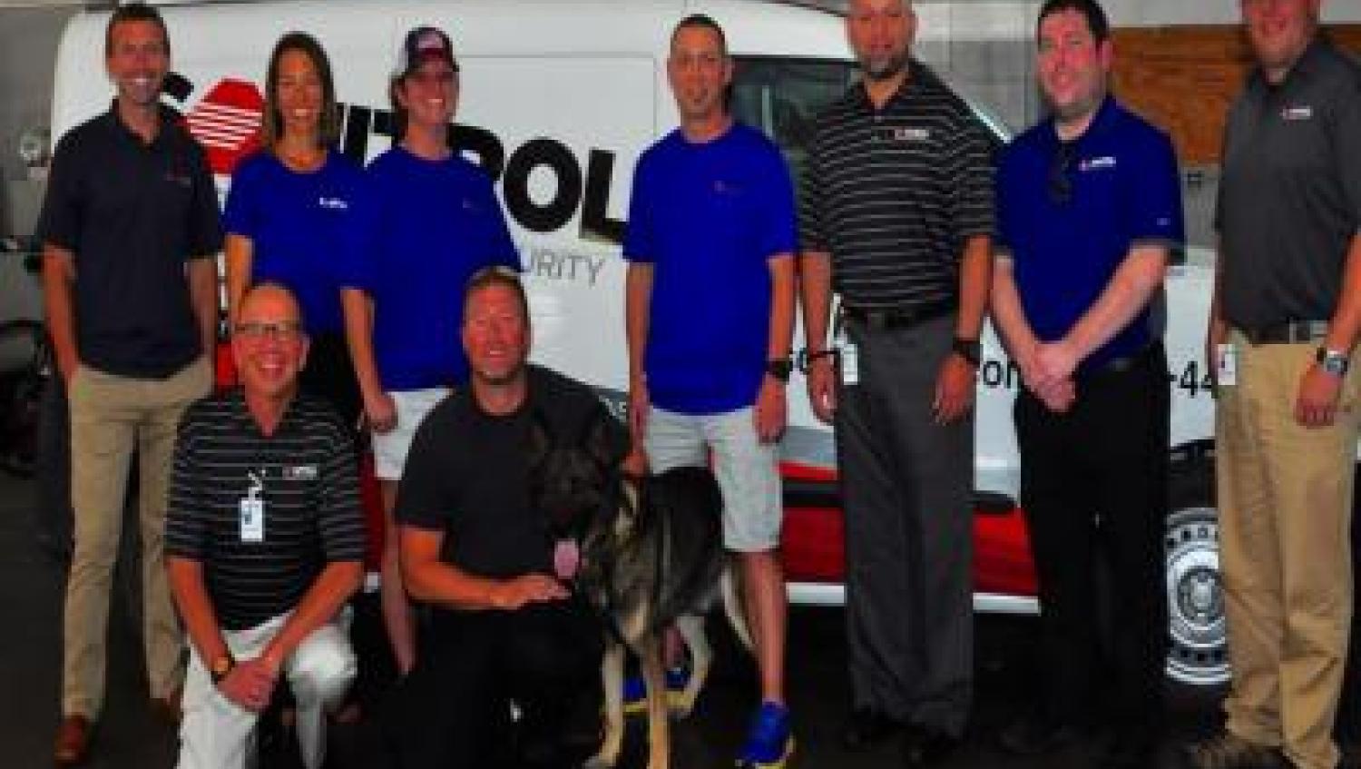 Sonitrol employees with k-9 in front of Sonitrol van