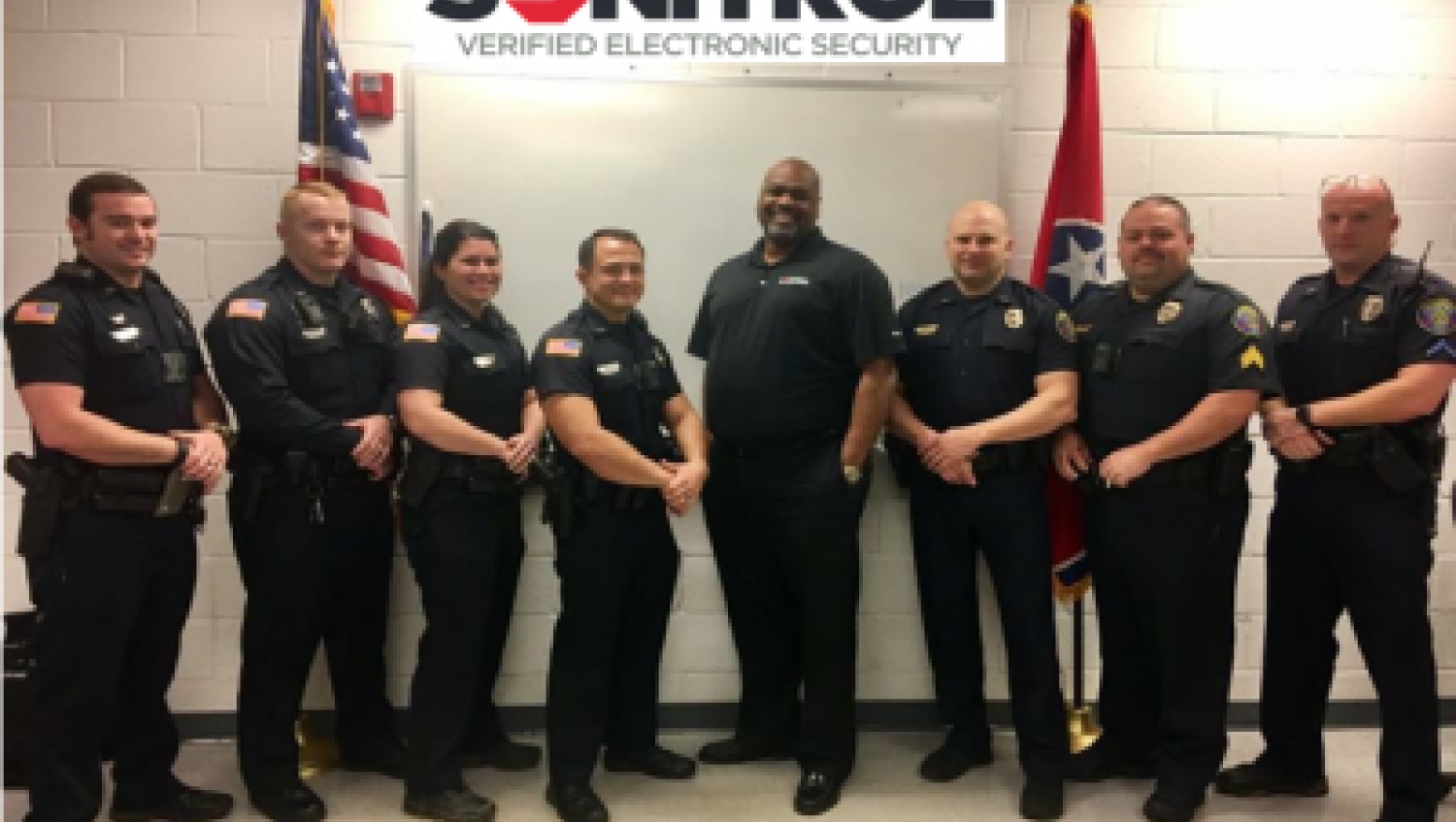 Cleveland Tennessee PD group photo, in front of Sonitrol banner