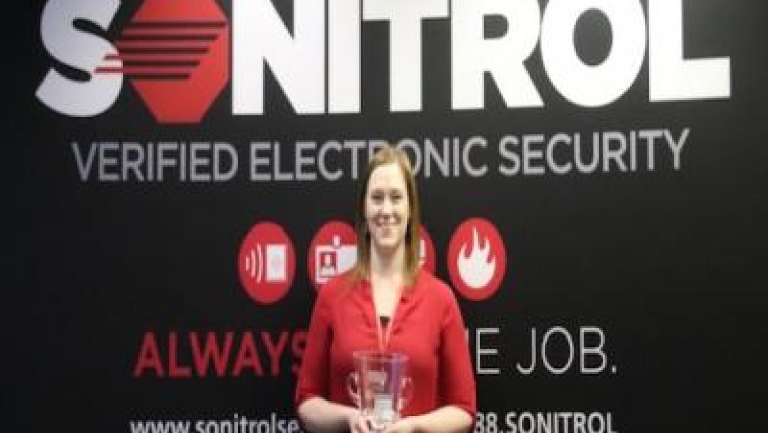 Sonitrol manager holds trophy