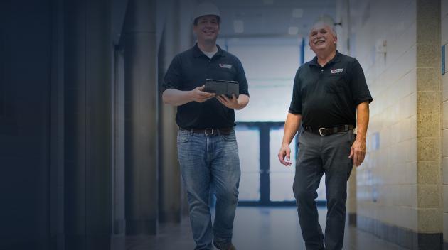 Two Sonitrol technicians inspecting hospital hallway system.