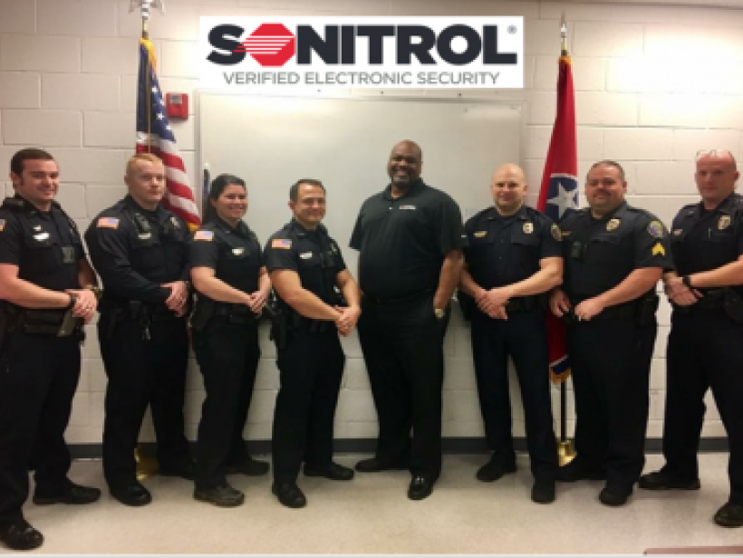 Cleveland Tennessee PD group photo, in front of Sonitrol banner