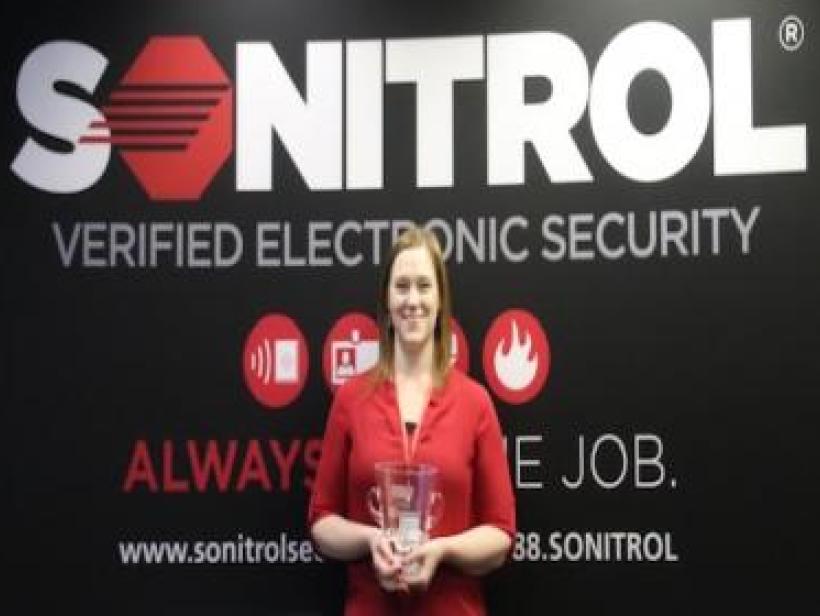 Sonitrol manager holds trophy
