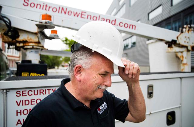 Sonitrol worker putting on construction hat